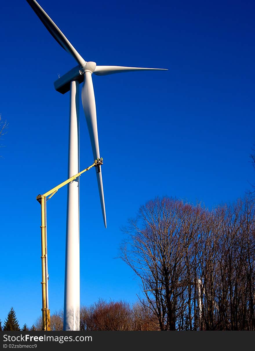 Engineer on windmill on blue sky