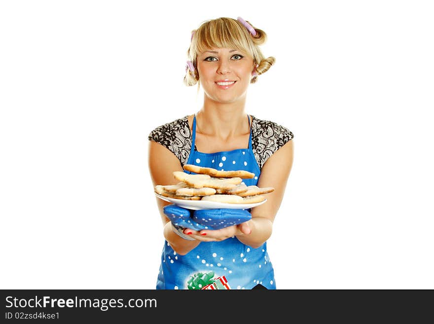 Pretty young woman in an apron and oven gloves holding a plate of gingerbread cookies for the little people christmas. Isolated on a white background. Pretty young woman in an apron and oven gloves holding a plate of gingerbread cookies for the little people christmas. Isolated on a white background