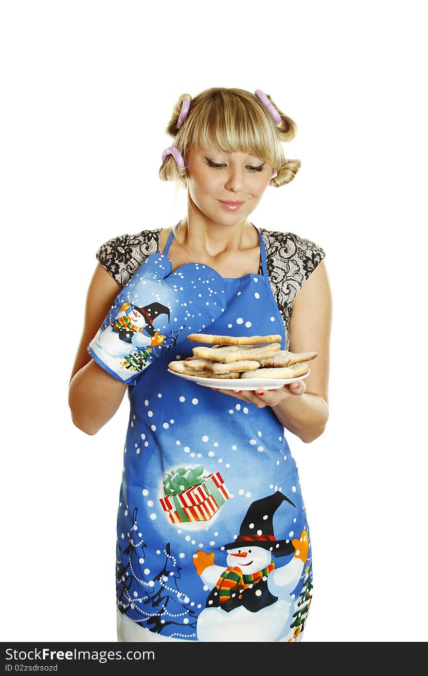 Pretty young woman in an apron and oven gloves holding a plate of gingerbread cookies for the little people christmas. Isolated on a white background. Pretty young woman in an apron and oven gloves holding a plate of gingerbread cookies for the little people christmas. Isolated on a white background