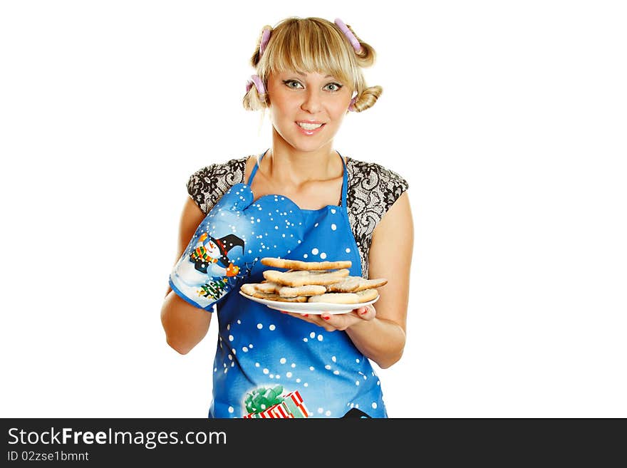 Pretty young woman in an apron and oven gloves holding a plate of gingerbread cookies for the little people christmas. Isolated on a white background. Pretty young woman in an apron and oven gloves holding a plate of gingerbread cookies for the little people christmas. Isolated on a white background