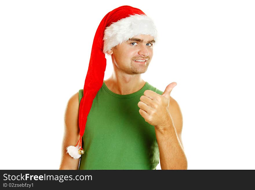 Young man in a Santa Claus hat and green poppy approvingly shows the thumb raised up. Isolated on a white background. Young man in a Santa Claus hat and green poppy approvingly shows the thumb raised up. Isolated on a white background