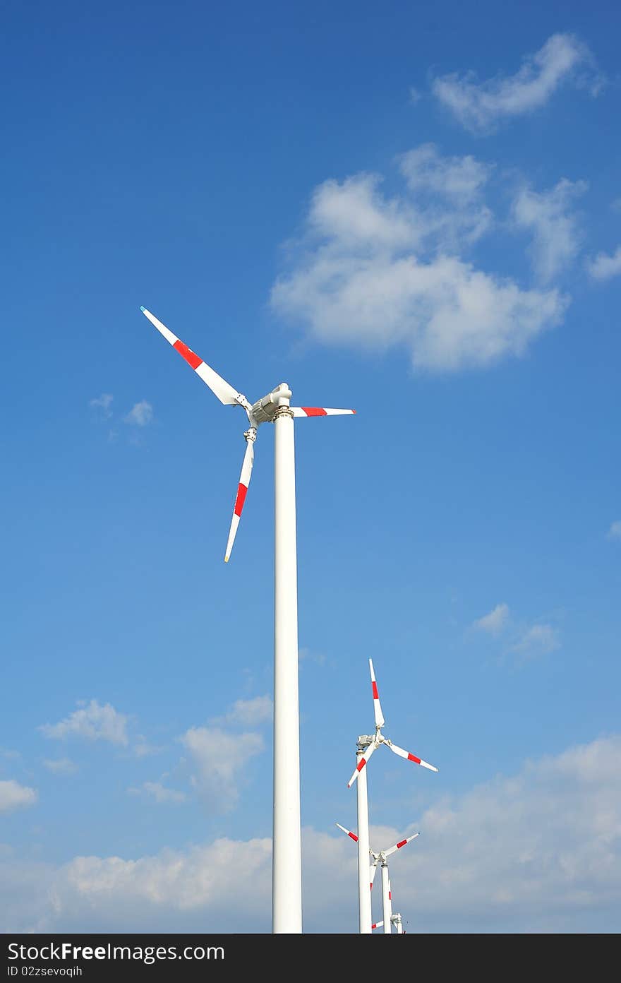 Wind turbines with red color on blue sky background