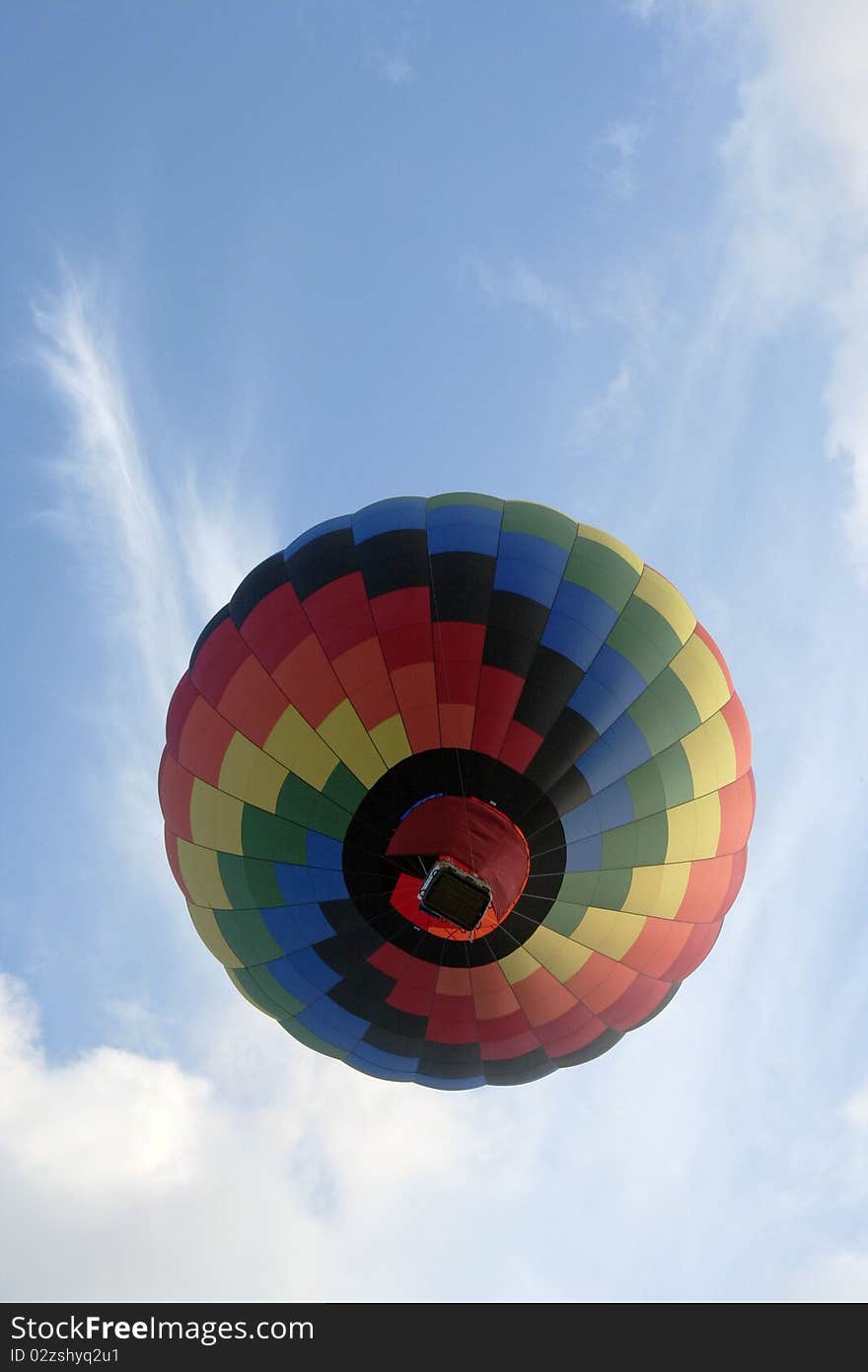 Colorful hot air balloon flying over head with blue sky. Colorful hot air balloon flying over head with blue sky