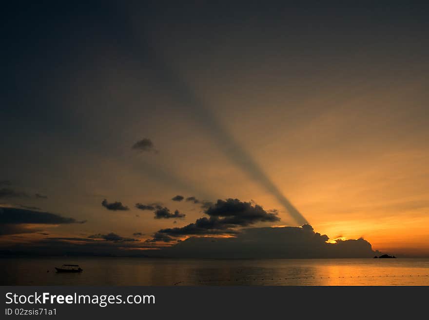 Boat drifting calmly on the ocean during a tropical ocean sunset