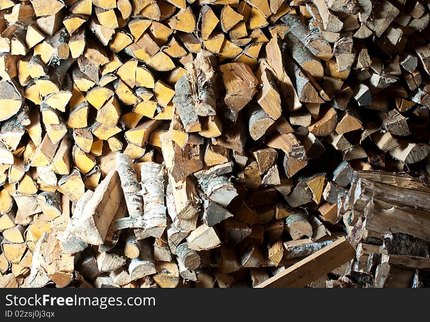 Stack of birch wood inside the woodshed. Stack of birch wood inside the woodshed.