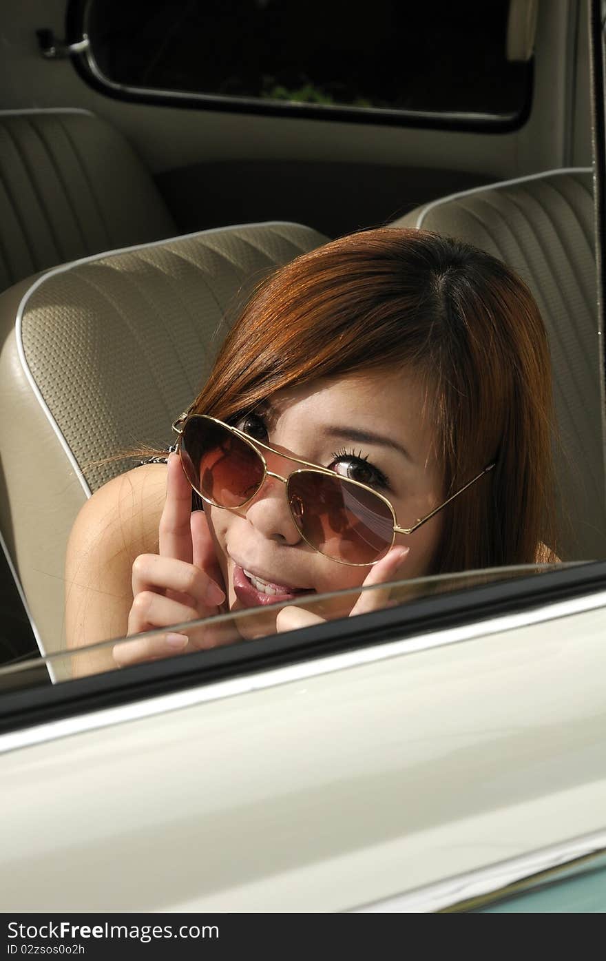 Girl in a car with sun glasses