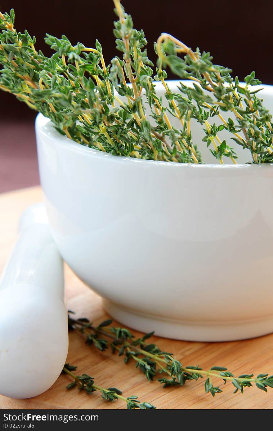 Mortar and pestle with herbs on a wooden board