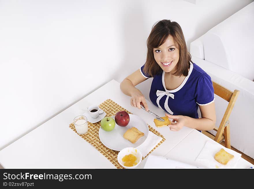 Young woman in breakfast, eating and using laptop. Young woman in breakfast, eating and using laptop