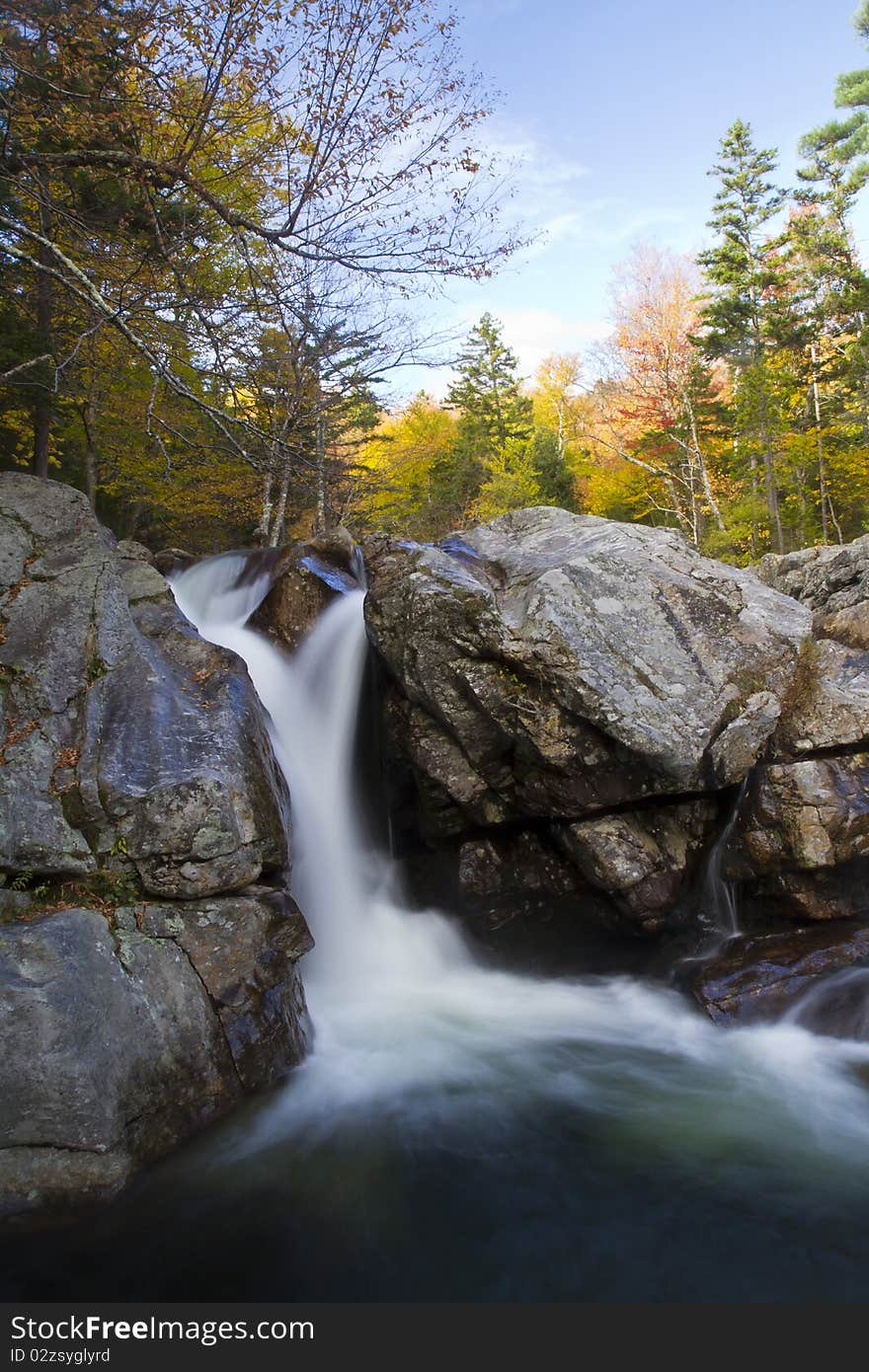 The Ellis river squeezes through a chute in the rocks making a beautiful waterfall in the fall foliage of Pinkham Notch, New Hampshire. The Ellis river squeezes through a chute in the rocks making a beautiful waterfall in the fall foliage of Pinkham Notch, New Hampshire.