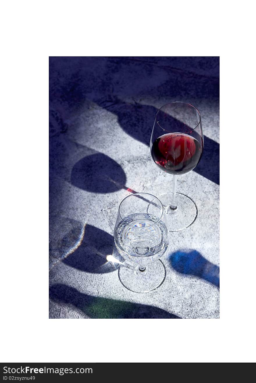 Glasses of red wine and water with shadows