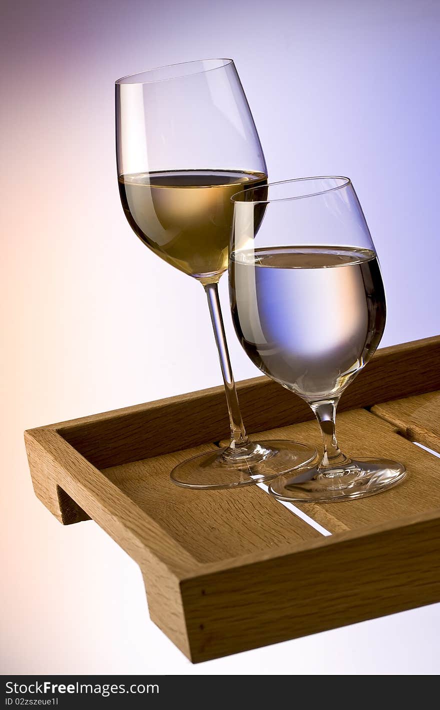 Glasses of white wine and water on a wooden tray