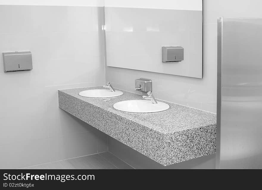 Hand wash sink from marble in a public restroom. Hand wash sink from marble in a public restroom.