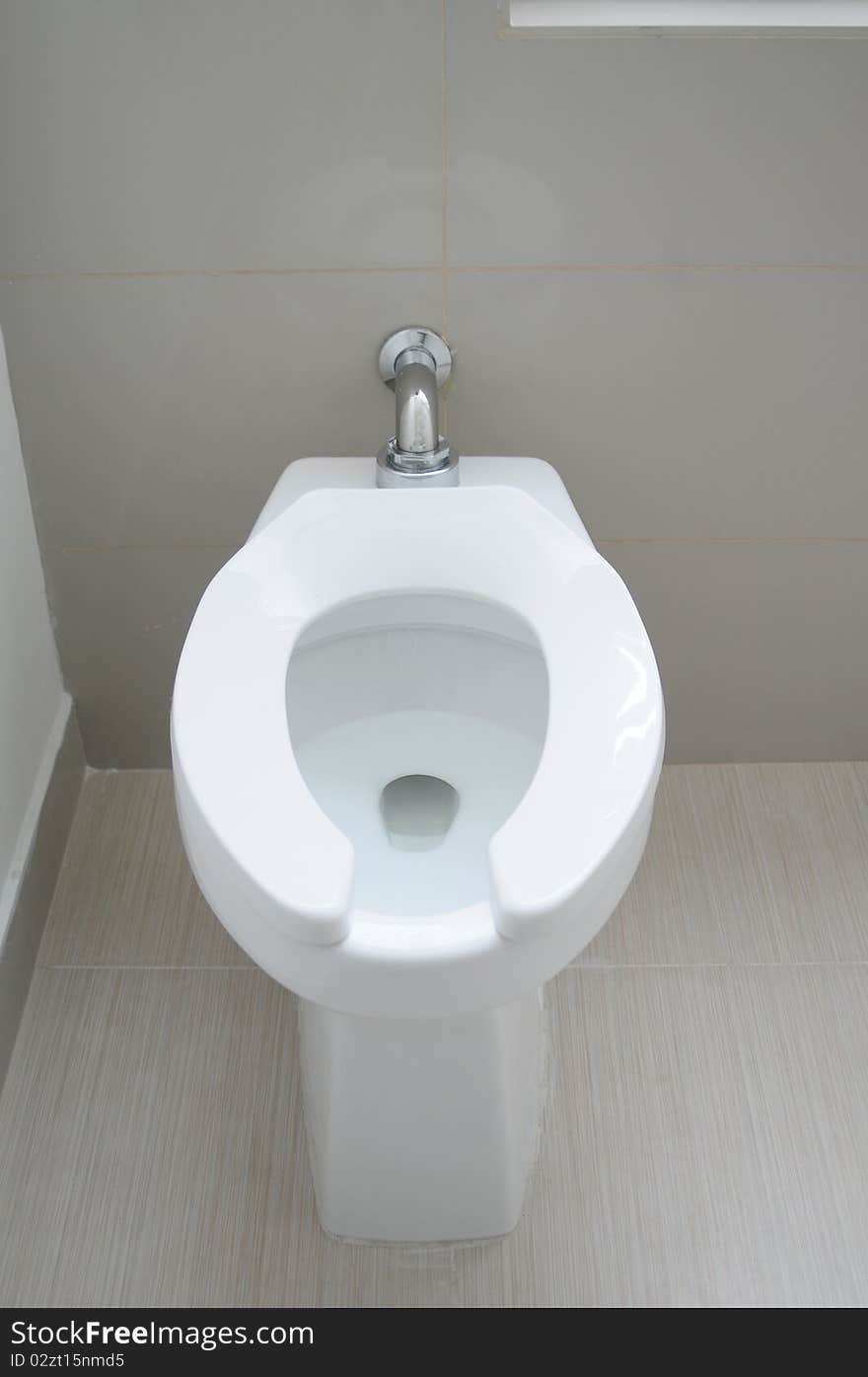 White toilet on a tiled floor. White toilet on a tiled floor.