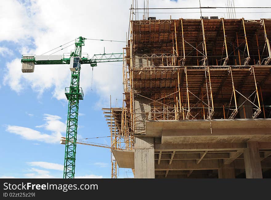 Crane in a construction site in front of a building. Crane in a construction site in front of a building.