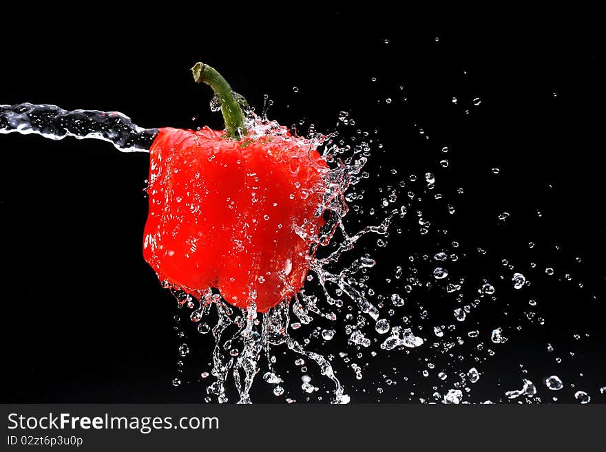 Red pepper gets hit by a water stream