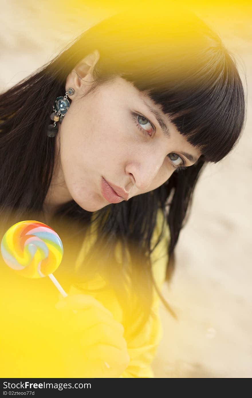 Portrait of a beautiful woman eating candy lollipops. Blurred background.