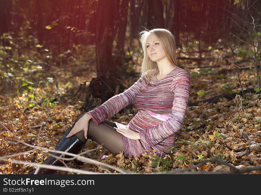 Beautiful pregnant woman in the autumn park.