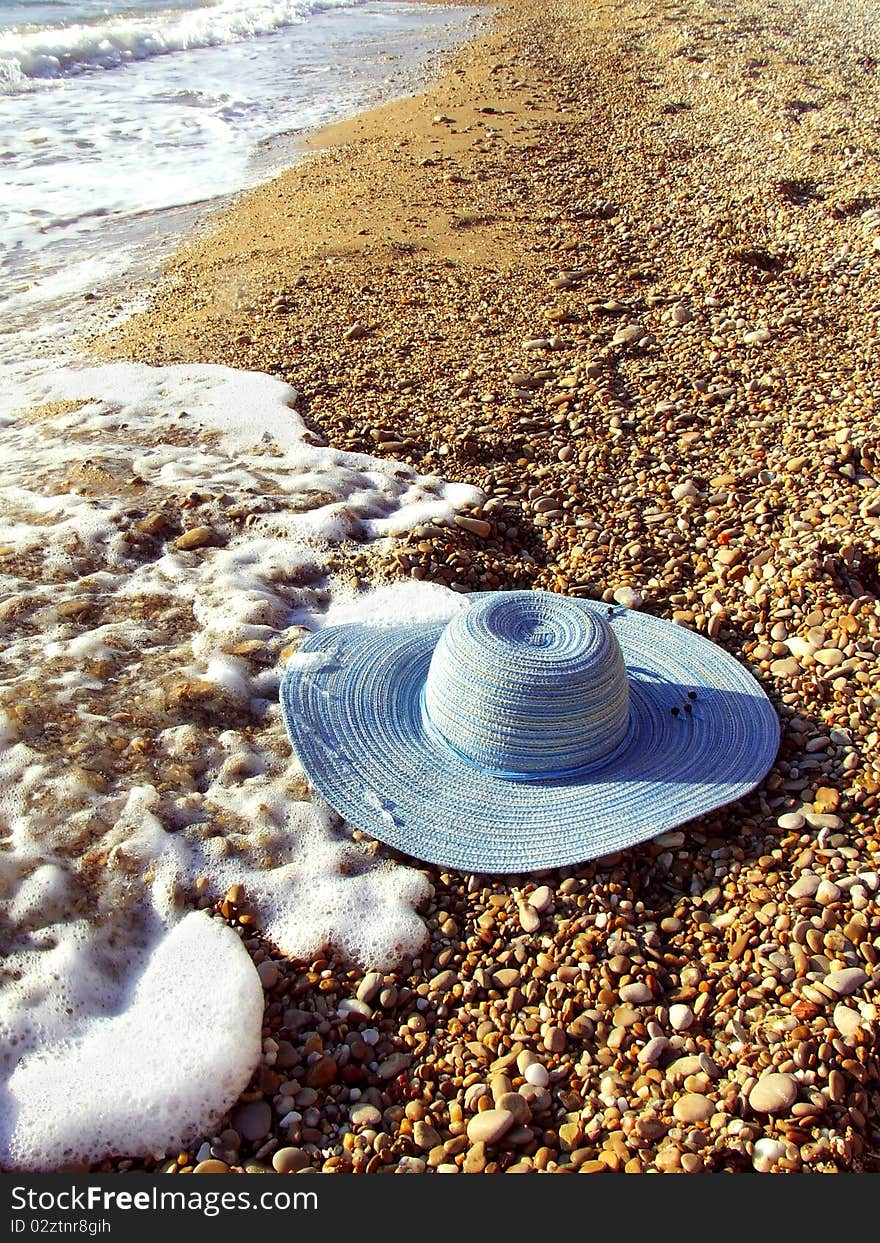 Sea And Women`s Hat On A Shingle Beach