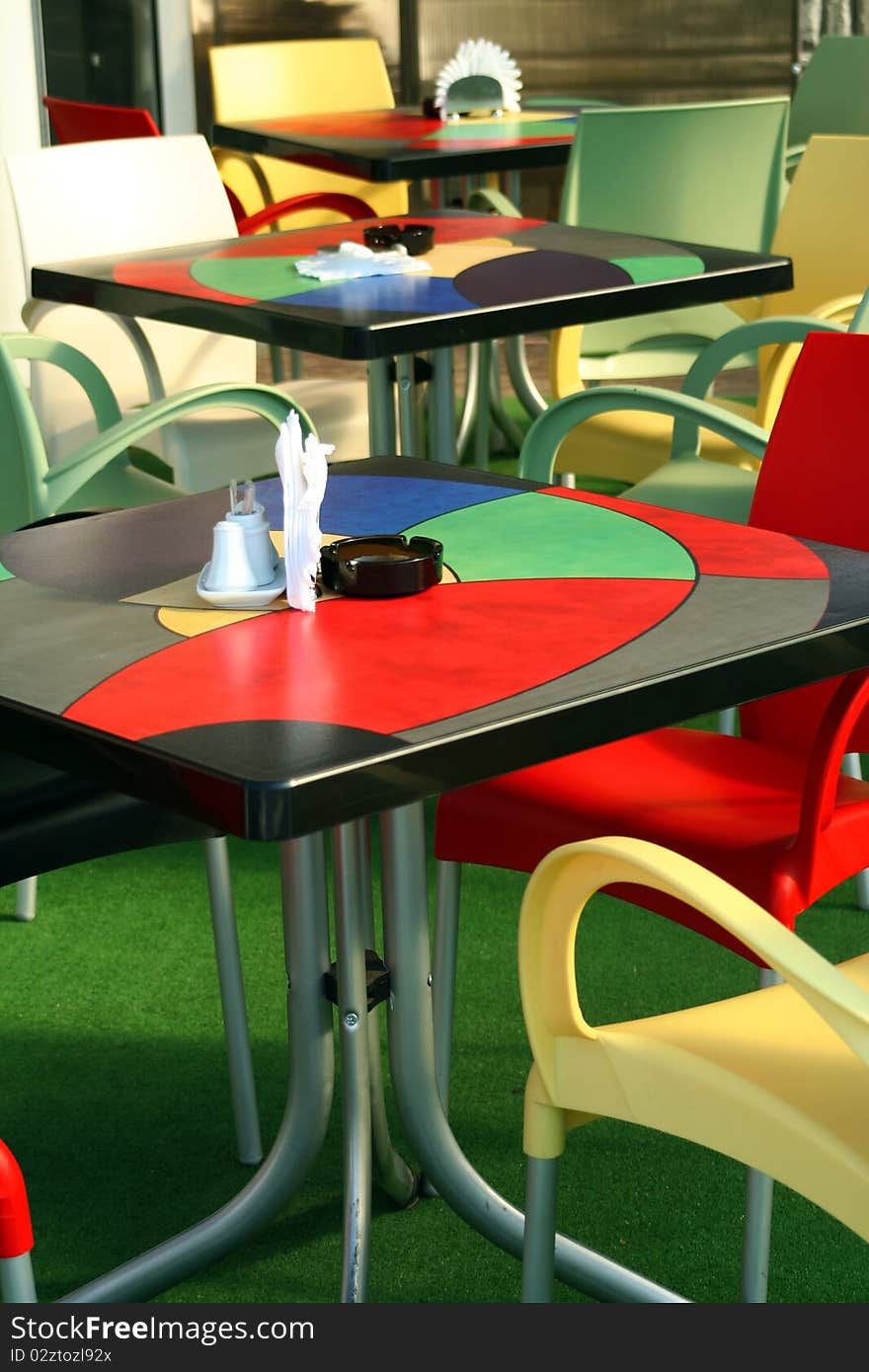 Three colored Tables and Chairs at Cafe