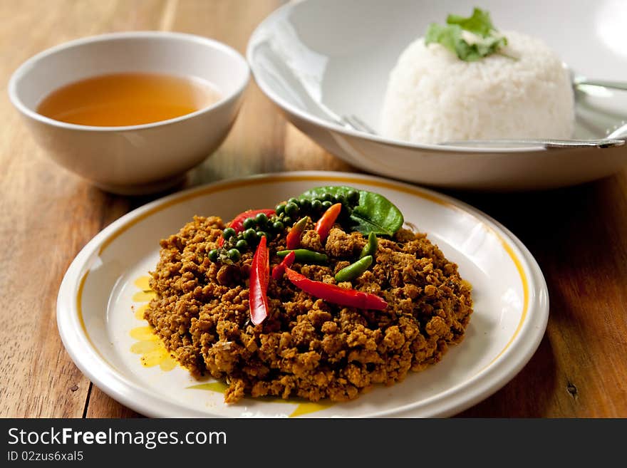 Spicy pork basil with rice and soup on wood background,thai food. Spicy pork basil with rice and soup on wood background,thai food.