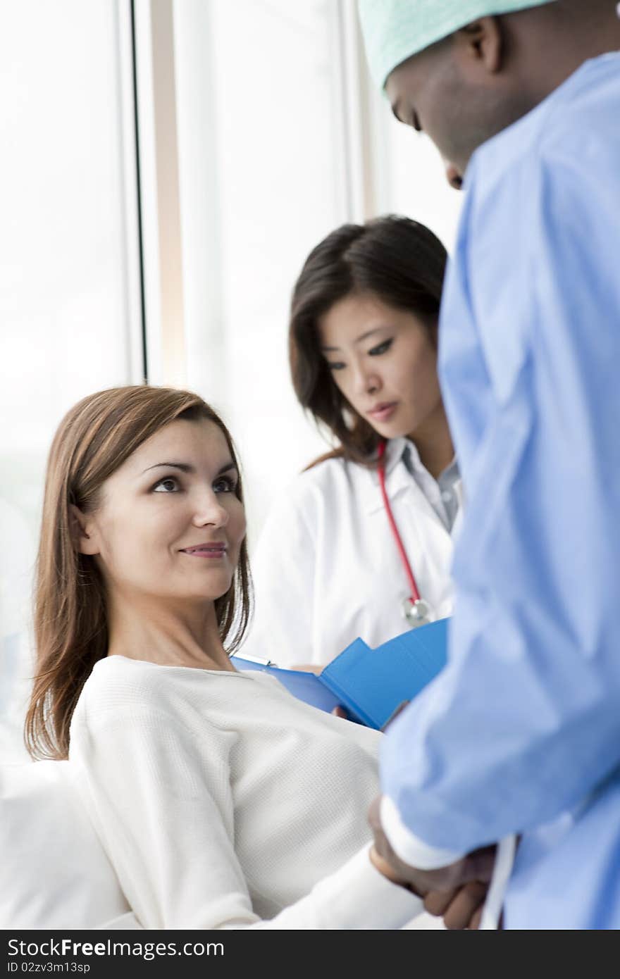 Doctor and surgeon speaking with a female patient. Doctor and surgeon speaking with a female patient