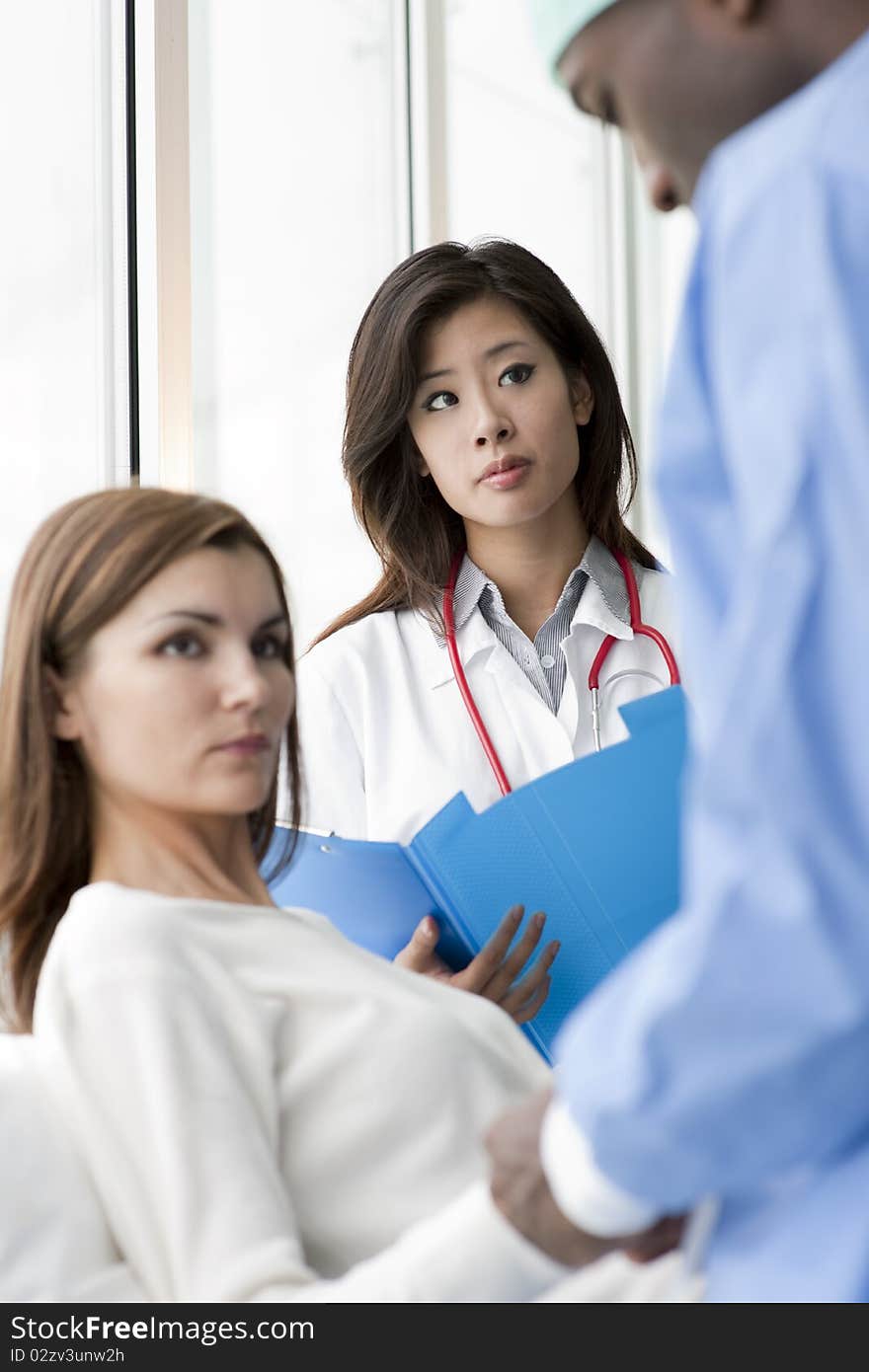 Doctor and surgeon speaking with a female patient. Doctor and surgeon speaking with a female patient