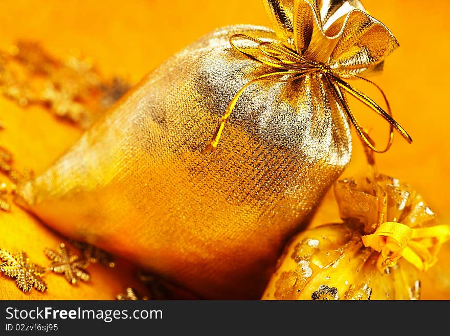 Two golden christmas gift sacks with ribbons over yellow background. Two golden christmas gift sacks with ribbons over yellow background