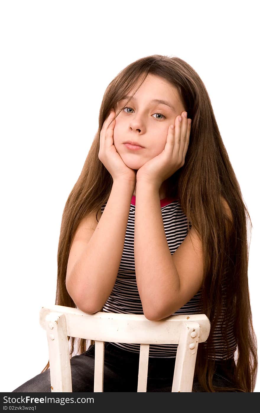 Pretty girl in the age of eleven looking ahead sitting on a chair isolated on white at age. Pretty girl in the age of eleven looking ahead sitting on a chair isolated on white at age