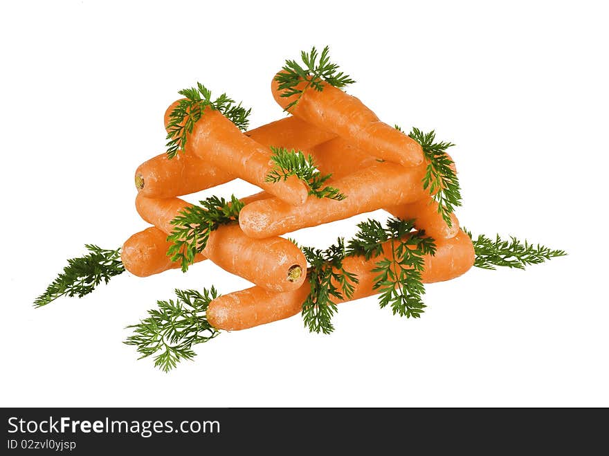 Carrots stacket up with leaves around on white background