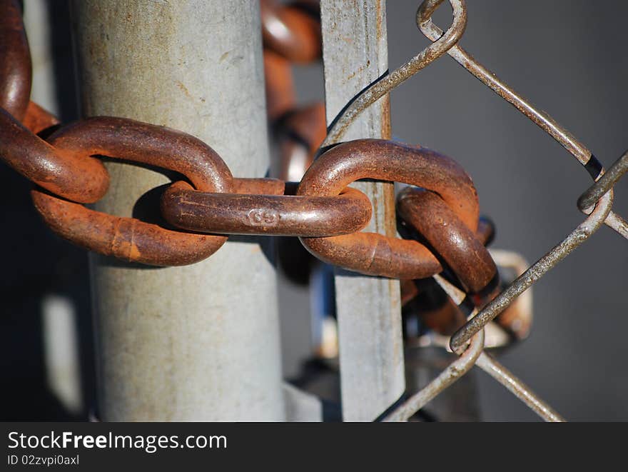 Steel chain closes the passage through the mesh gate.