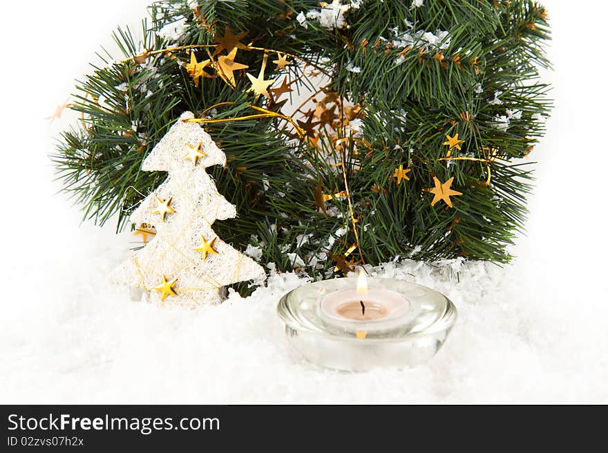 Christmas wreaths with burning candle on the snow