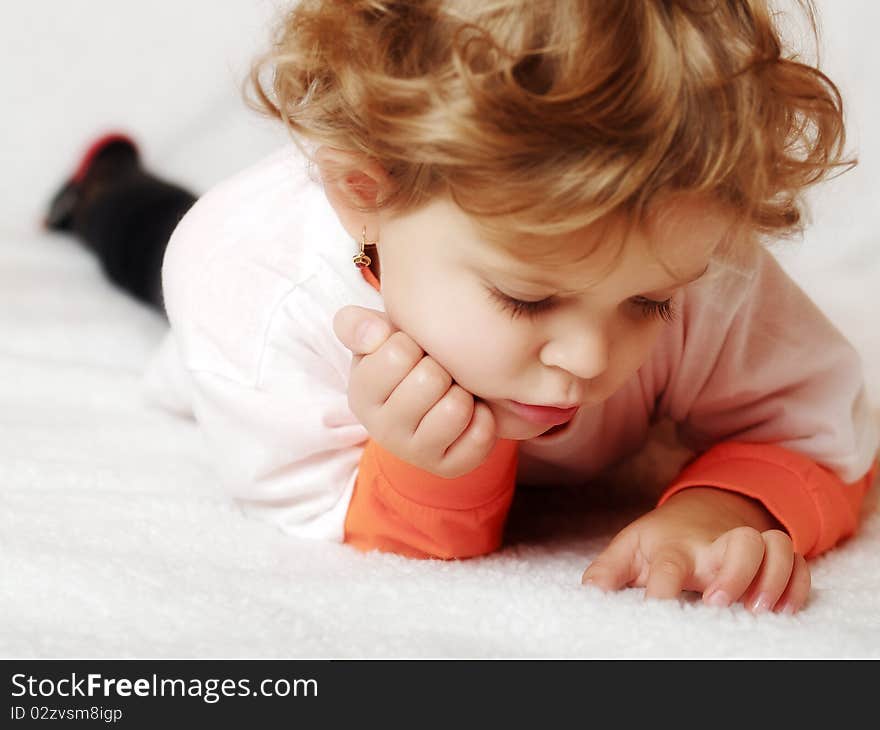 Thoughtful little girl lying in bed. Thoughtful little girl lying in bed