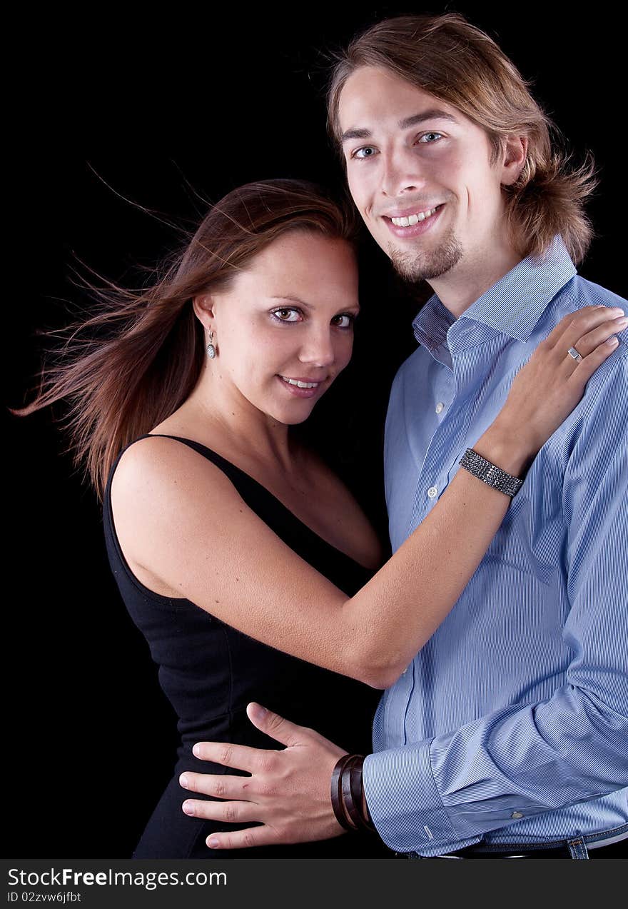 Young cute couple with long hair over black background. Young cute couple with long hair over black background.