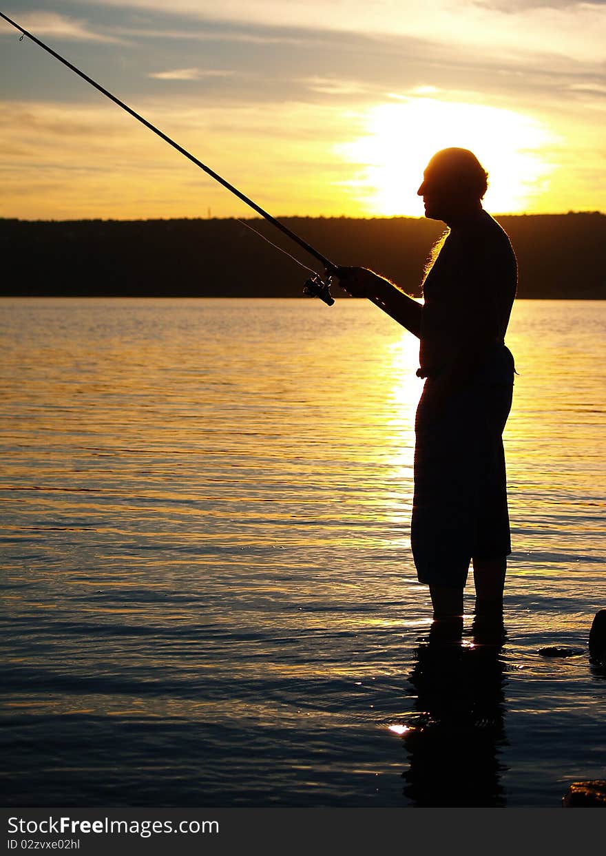 Man fishing on the coast of sea in sunset. Man fishing on the coast of sea in sunset