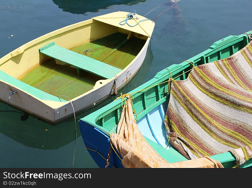 Close up of two small, brightly painted boats floating in a harbour. Close up of two small, brightly painted boats floating in a harbour.