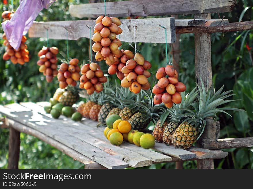 Fruit for sale by a road in the middle of a rainforest in Madagascar. Focus on right hand side of image. Fruit for sale by a road in the middle of a rainforest in Madagascar. Focus on right hand side of image