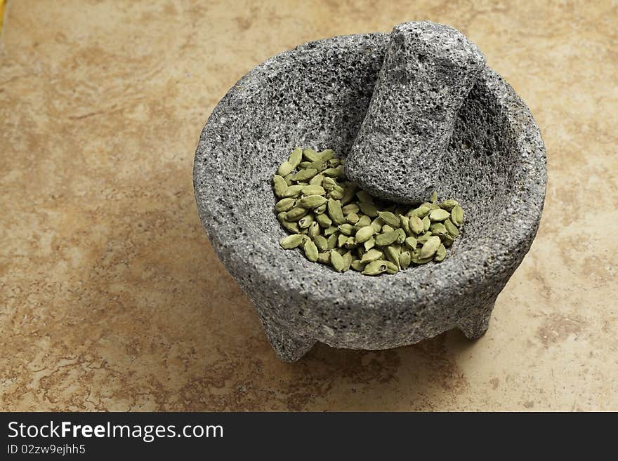 Cardamom seeds green in a stone mortar and pedestal. Cardamom seeds green in a stone mortar and pedestal.