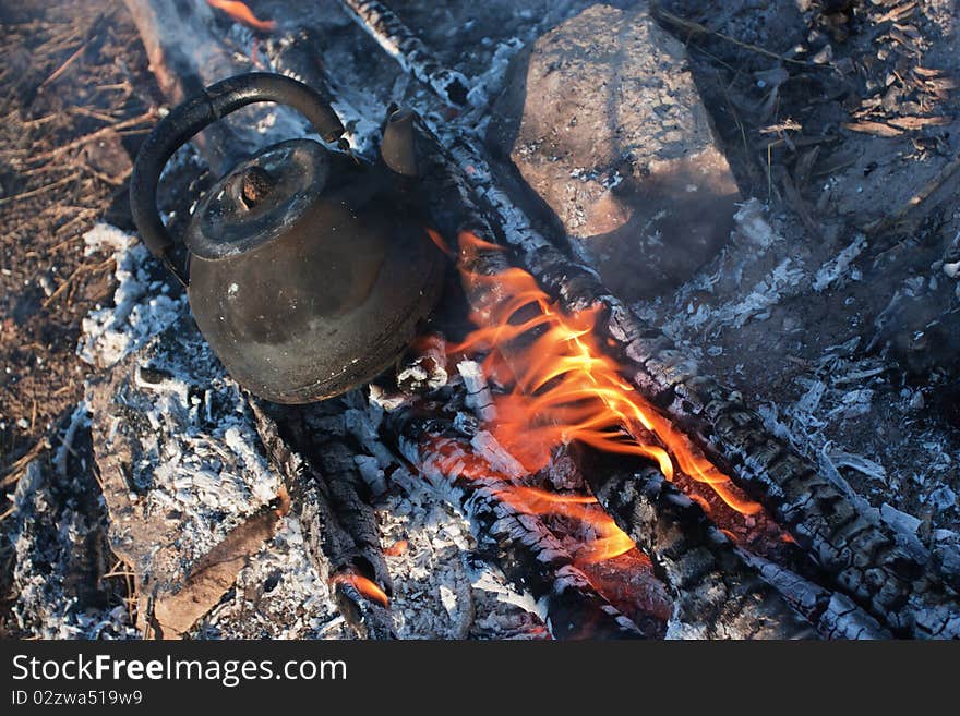 Old teapot on campfires. Rest on nature.