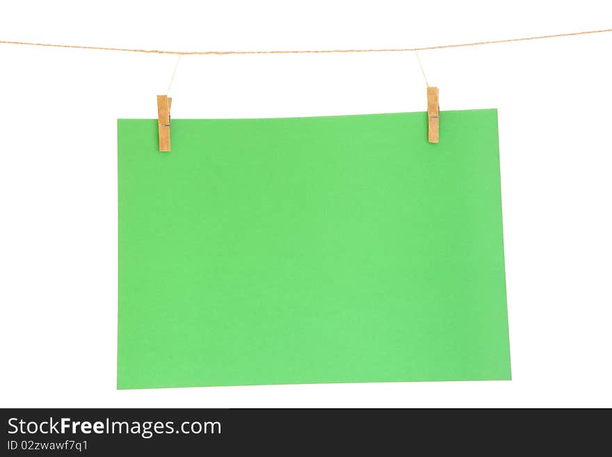 Green blank paper sheet on a clothes line. Isolated on white background. Green blank paper sheet on a clothes line. Isolated on white background.