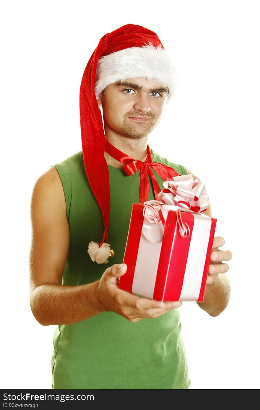 Young man in a Santa Claus hat and green poppy stretched to frame the big red Christmas box. Young man in a Santa Claus hat and green poppy stretched to frame the big red Christmas box