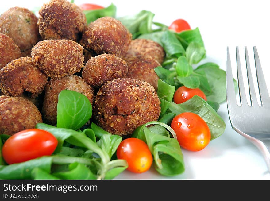 Meatballs with fresh vegetables isolated in white