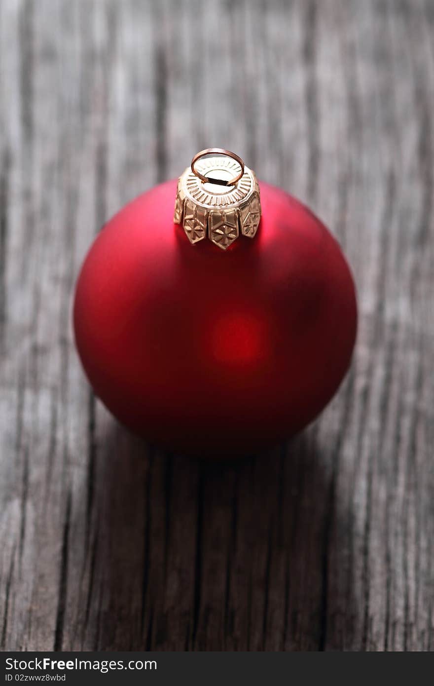 One red christmas ball on the wooden background