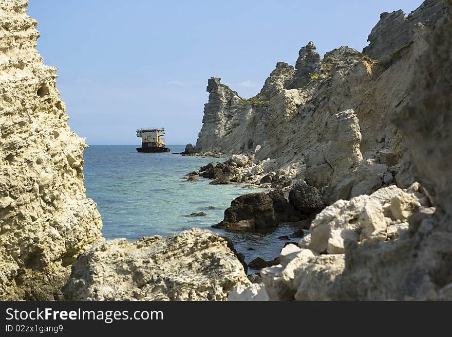 Grounded rusty ship on the sea cliffs