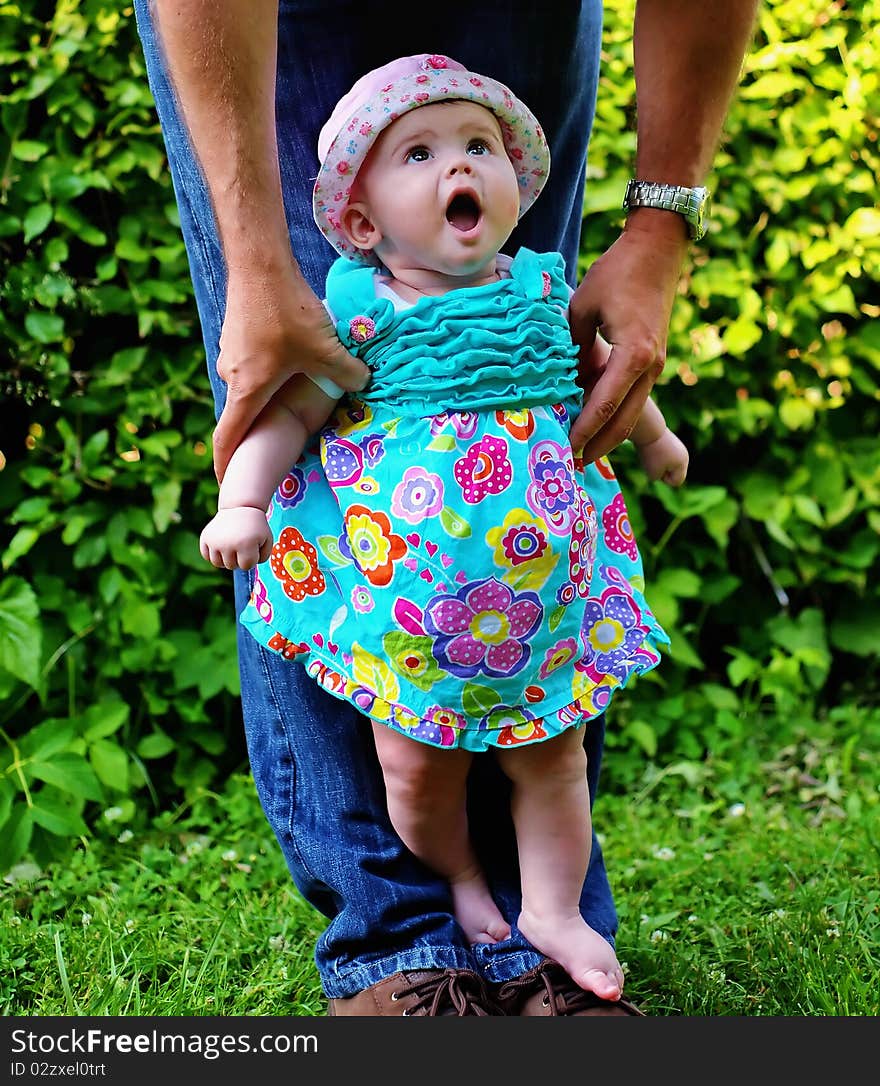 Baby girl looking to dad and standing. Baby girl looking to dad and standing