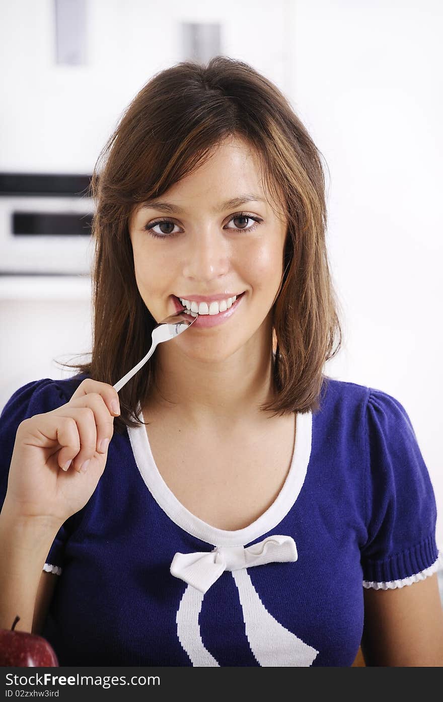 Young woman with spoon on lips