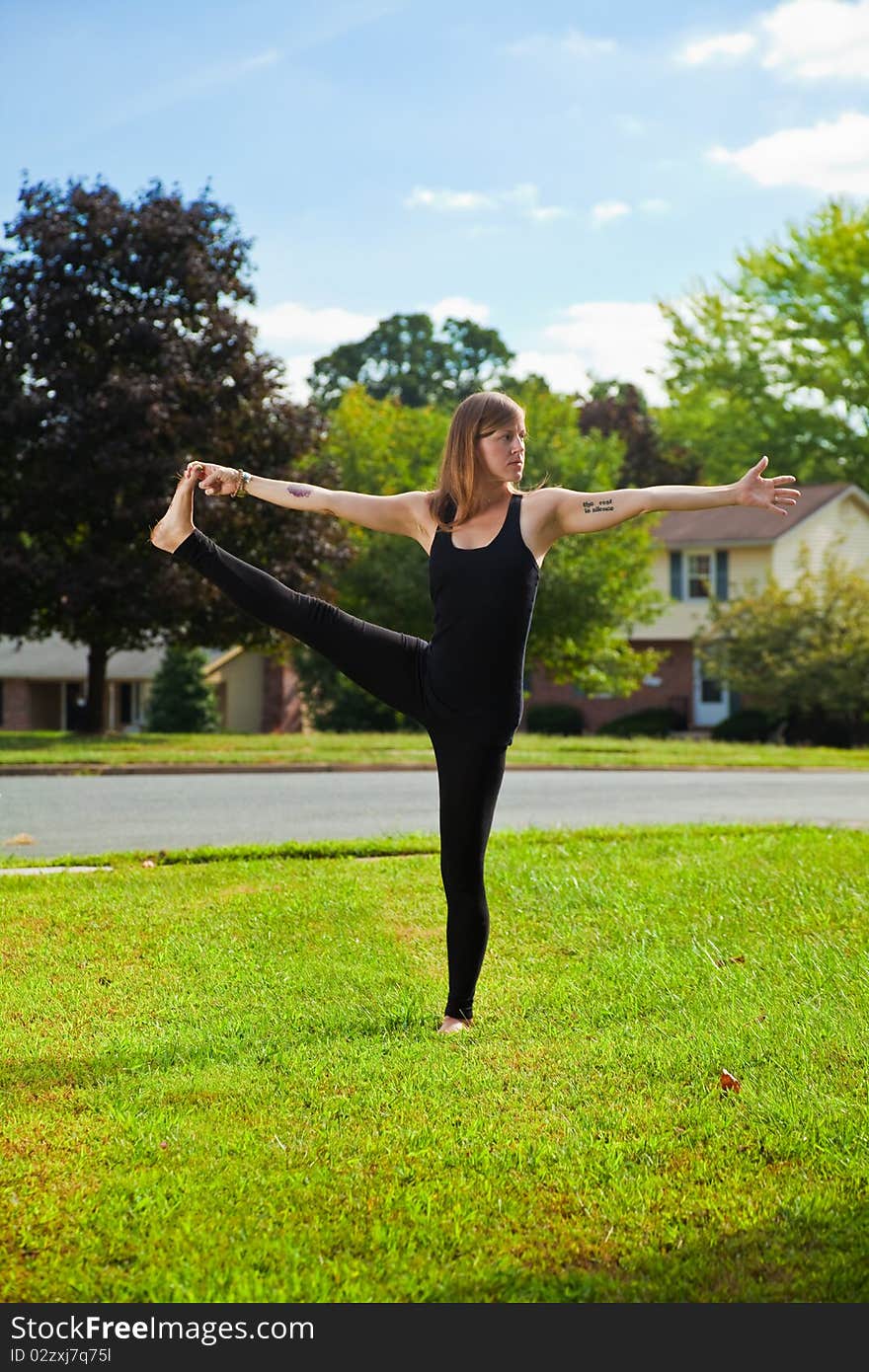 Young girl doing yoga exercise alone on the lawn