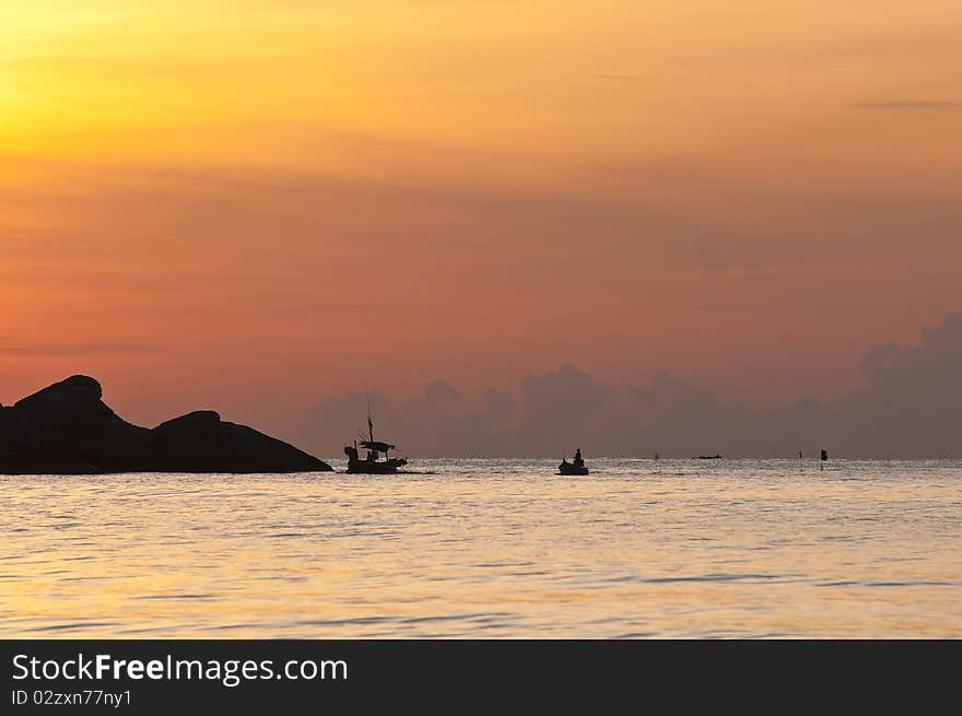 The sun is about to fall evening at sea. The island and the fishing boat to shore power. The sun is about to fall evening at sea. The island and the fishing boat to shore power