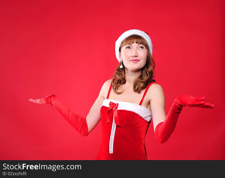 Portrait of a young girl dressed as Santa Claus on a red background. Happy New Year and Merry Christmas!