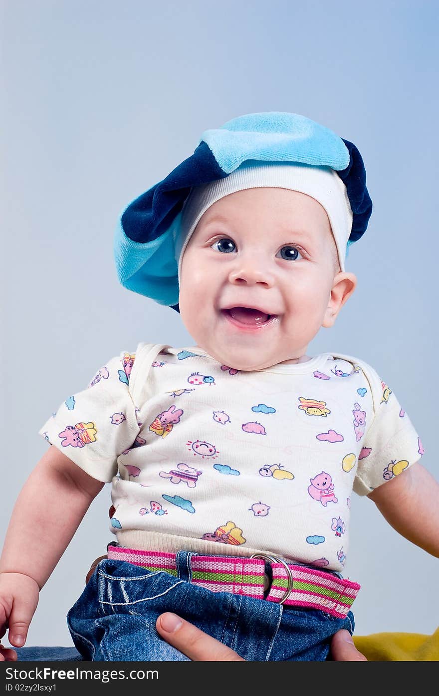 Amusing baby boy in a beret in a studio on a dark blue background