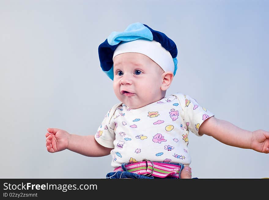 Amusing baby boy in a beret in a studio on a dark blue background